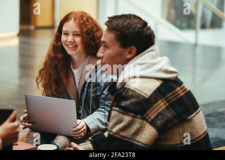 Friends studying together at university. Students sitting together and discussing some topics in group study. Stock Photo