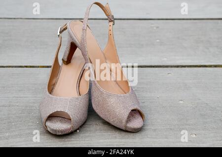 Pair of summer shoes with high heels on wooden surface. Stock Photo