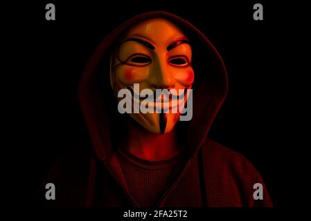 New York, USA - 22 april 2021: man wearing vendetta mask with hoodie on black background. This mask is symbol for Anonymous hackers group and for anti Stock Photo