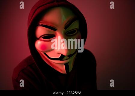New York, USA - 22 april 2021: man wearing vendetta mask with hoodie on black background. This mask is symbol for Anonymous hackers group and for anti Stock Photo