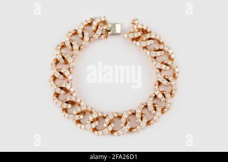 Golden bracelet with diamonds on gray background. Luxury yellow gold diamond jewelry bracelet Stock Photo