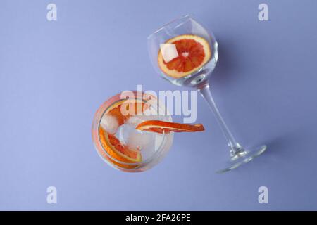 Glass of cocktail with grapefruit on violet background Stock Photo