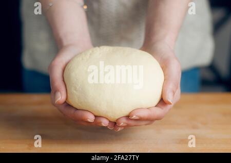 Woman holds bread dough in her hands Stock Photo