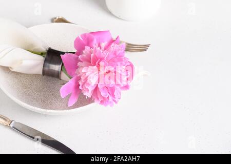 Elegance romantic table setting with pink peony flowers on a white table. Close up. Copy space. Stock Photo