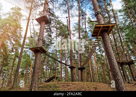 rope obstacle track high in the trees in adventure park Stock Photo