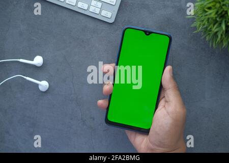 flat composition of hand holding smart phone on black background  Stock Photo