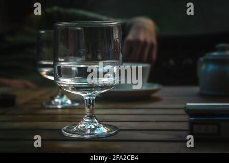 On the table of the cafe with friends, a glass of half of the water. Close up Stock Photo
