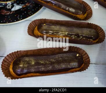 Gorgeous extra chocolate eclairs with gilded glaze Stock Photo
