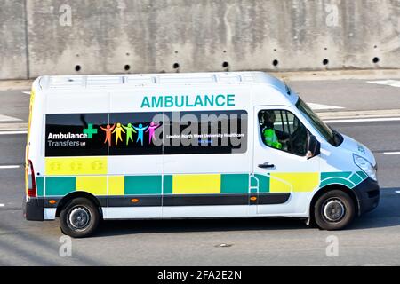 Side view driver & vehicle operator Ambulance Transfers Ltd a private business linked to London North West University Healthcare NHS Trust UK motorway Stock Photo