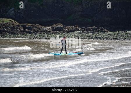 BRAY, IRELAND - Apr 03, 2021: A man on a SUP (stands up paddle board) on sea at Irish East coast. Stand up paddle boarding in Ireland. Water activity Stock Photo