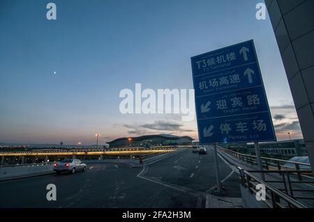 View of the approach road to the terminal in the twilight at Ürümqi Diwopu International Airport (IATA: URC, ICAO: ZWWW), an airport serving domestic and international flights in and out of Ürümqi, the capital of the Xinjiang Uygur Autonomous Region in northwestern China, PRC. © Time-Snaps Stock Photo