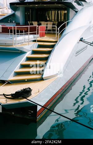 Side view of a stern trawl of beautiful motor white yacht moored to the pier Stock Photo