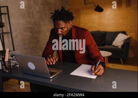 black business man working on laptop and taking notes Stock Photo