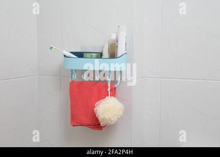 bathroom shelf with bathroom accessories against the white tile wall Stock Photo