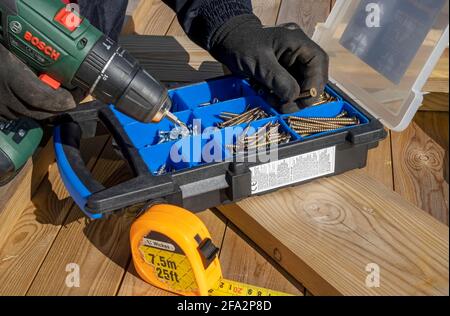 Close up of man person selecting choosing screw screws for cordless screwdriver England UK United Kingdom GB Great Britain Stock Photo