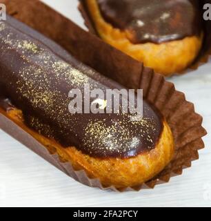 Gorgeous extra chocolate eclairs with gilded glaze Stock Photo