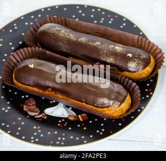 Gorgeous extra chocolate eclairs with gilded glaze Stock Photo