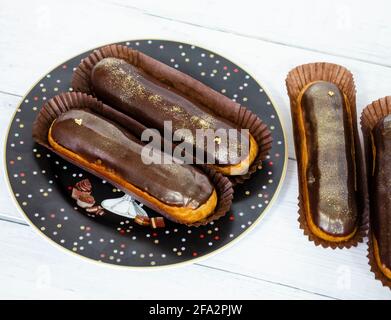 Gorgeous extra chocolate eclairs with gilded glaze Stock Photo