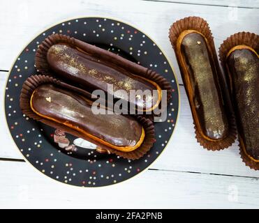 Gorgeous extra chocolate eclairs with gilded glaze Stock Photo