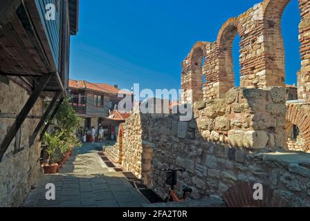 A street in Nessebar, Bulgaria, between the typical Nessebar houses and ancient ruins. Stock Photo