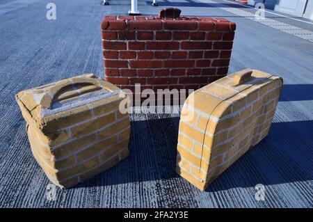 Unusual brick suitcases in the summer sun on a railway platform. Amsterdam. Stock Photo