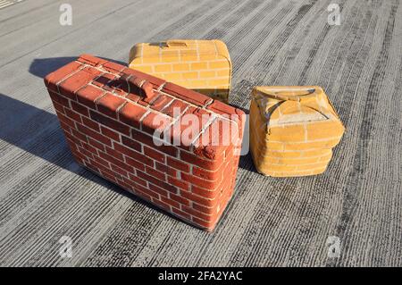 Unusual brick suitcases in the summer sun on a railway platform. Amsterdam. Stock Photo