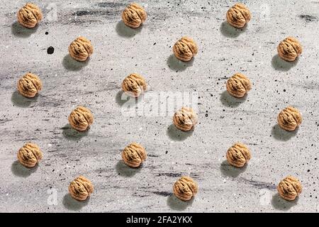 The whole unpeeled walnuts pattern on grey stone background. A trendy hard light, dark shadow, flat lay, mockup, template Stock Photo