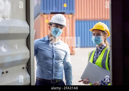 Industrial worker woman and engineer control worker checking in front door of cargo container at container cargo harbor Stock Photo