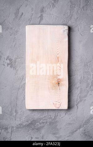 Handcrafted white old wooden cutting board on stone concrete background, top view Stock Photo