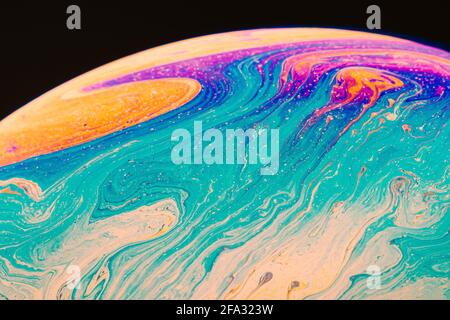 Fluid art made of colorful soap bubble film. Trendy Inkscape blurred background. Alien space planets art. Selective focus. Stock Photo