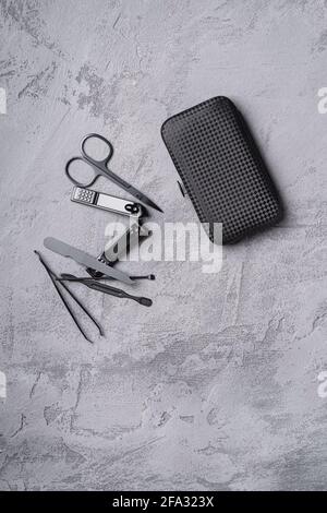 Set of manicure, pedicure tools and accessories with case, stone concrete background, top view Stock Photo