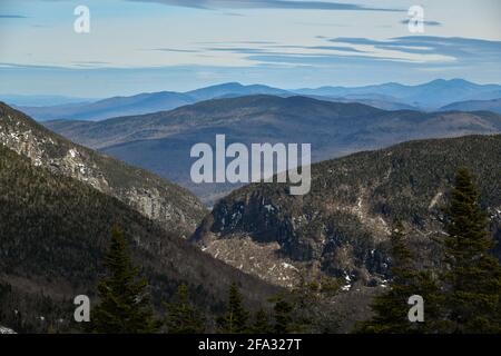 View from Mt. Mansfield Vermont at Stowe ski resort to Notch Path to Smugglers Notch. Late spring time with snow on the mountains and blue sky with cl Stock Photo