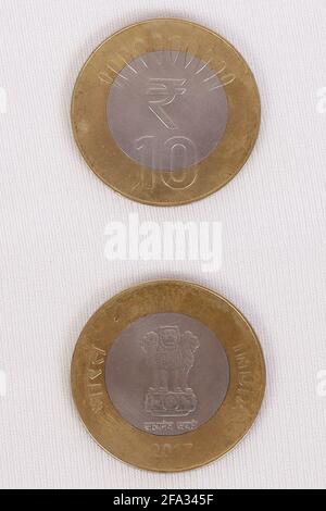 Indian Rupee Coins. Ten rupees coins stacked vertically. On a white ...