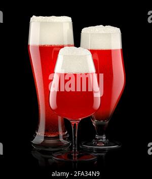 Set of fresh stout beer glasses with bubble froth isolated on black background. Stock Photo