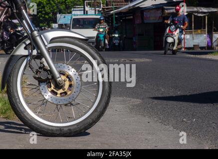 Front wheel of motorcycle on street, in Indonesia Stock Photo