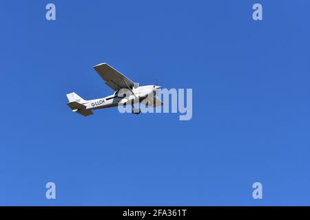 A Cessna C172S G-LLCH light aircraft in the skies over Lulsgate, Bristol Airport with a beautiful blue sky background Stock Photo