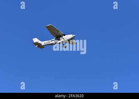 A Cessna C172S G-LLCH light aircraft in the skies over Lulsgate, Bristol Airport with a beautiful blue sky background Stock Photo
