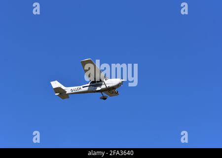 A Cessna C172S G-LLCH light aircraft in the skies over Lulsgate, Bristol Airport with a beautiful blue sky background Stock Photo