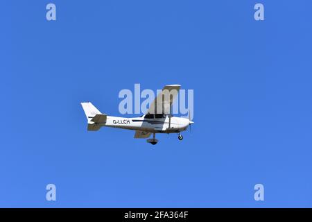 A Cessna C172S G-LLCH light aircraft in the skies over Lulsgate, Bristol Airport with a beautiful blue sky background Stock Photo