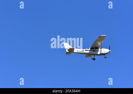 A Cessna C172S G-LLCH light aircraft in the skies over Lulsgate, Bristol Airport with a beautiful blue sky background Stock Photo