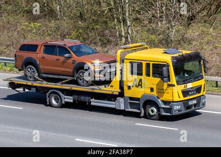 AA, roadside assistance for 2918 Ford Ranger Wildtrak 4x4 Tdci,  transporting, commercial, driven, symbol, automobile, way, moving, british, road transport, traffic, drive, driver, AA, breakdown recovery, low loader, British roads, MAN vehicles, driving, vehicle, car, motorway, uk, england, isolated, passenger, passengers, freeway, city, speed, street, in motion, urban, modern, background, traveling, movement, landscape, truck, AA van, highway, traffic lanes, 24hr emergency roadside recovery, double cab, towing equipment,  24/7 Stock Photo