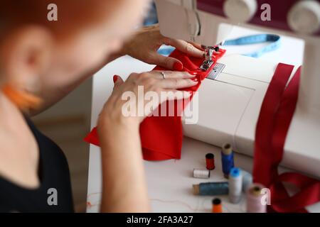 Close-up of professional female tailor using sewing machine Stock Photo