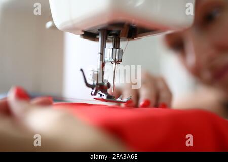 Close-up of needle on sewing machine with red thread. Metal details Stock Photo
