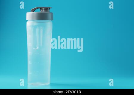 Shaker is an empty plastic smoothie cup on a blue background. Free space, minimalistic concept Stock Photo