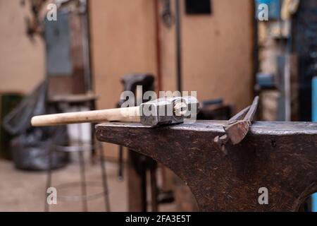 Tools for forging in a blacksmith shop. The hammer and pliers lie on the anvil. Stock Photo