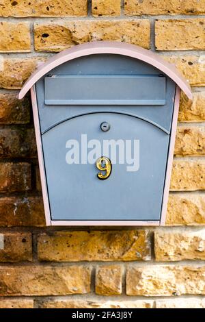 mailbox with the number nine on a stone wall of yellow brick. High quality photo Stock Photo