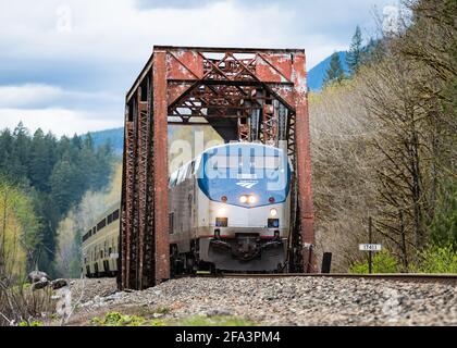 The Eastbound Empire Builder to Chicago crosses an original Great Northern bridge over Barclay Creek in Western Washington Stock Photo