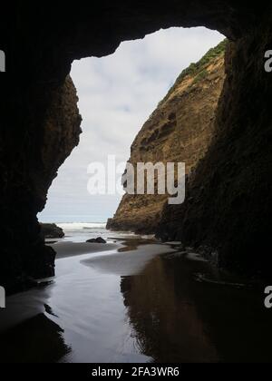 from darkness of Piha Blowhole cave to ocean Stock Photo