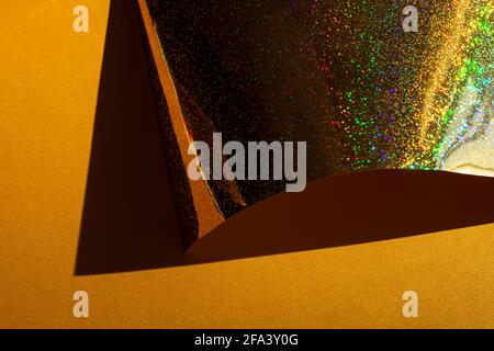 Composition with gold holographic paper. Retro futuristic style. Selective focus. Stock Photo