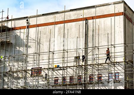 Pontypridd, Wales - April 2021: Worker walking across a platform on scaffolding around the old County Cinema in Pontypridd town centre. Stock Photo